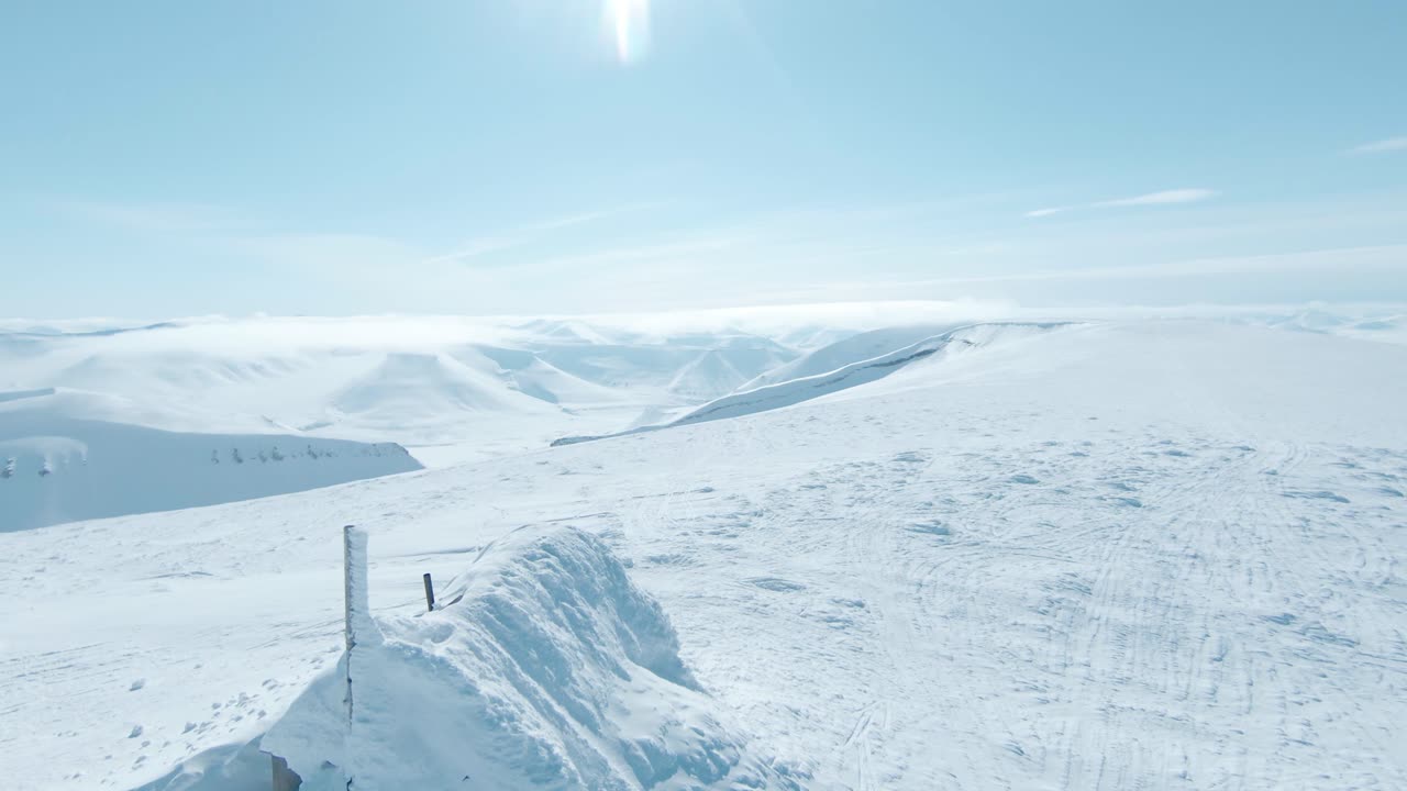 スヴァールバル諸島の山頂にある、厚い雪に覆われた古い小屋の空撮