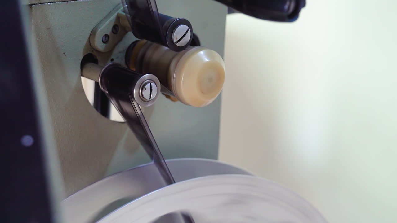 영화 릴은 조명 방에서 빈티지 영화관 장비에 옮겨졌습니다.