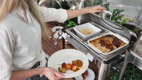 woman serving food at a buffet