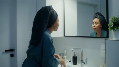 woman applying skincare in the bathroom