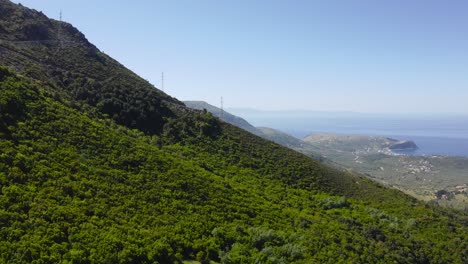 empinada ladera de la montaña en la cordillera del parque nacional de llogara completamente cubierta de arbustos verdes con hermosas vistas del mar adriático en un día soleado en albania