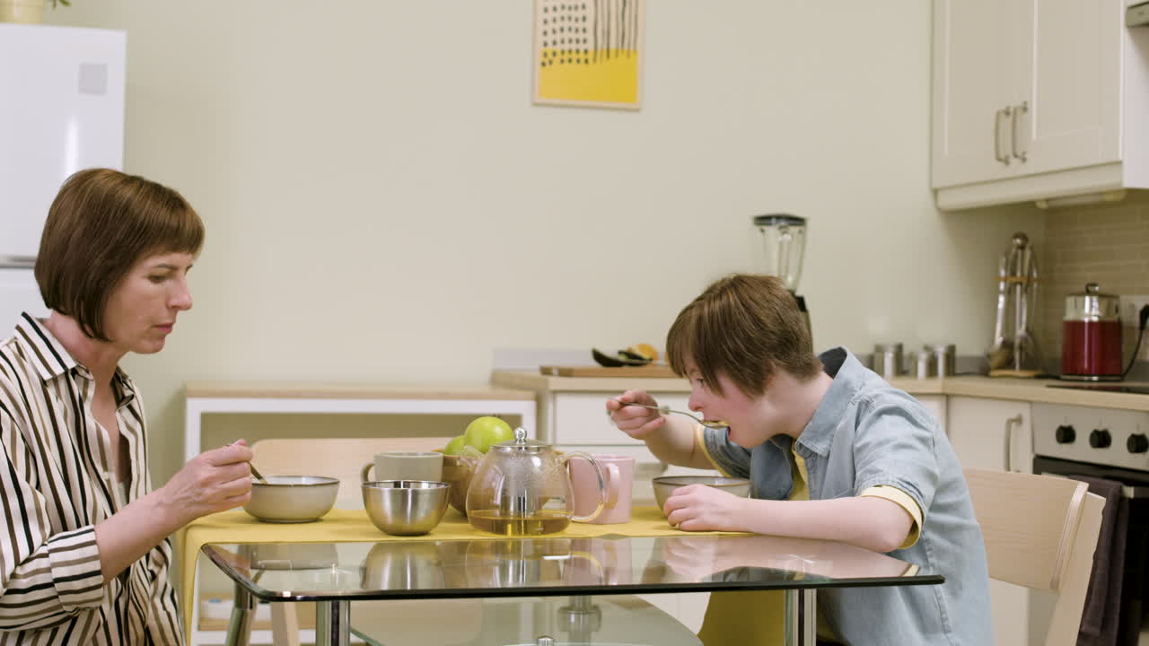 молодая девушка и ее мать разговаривают и завтракают