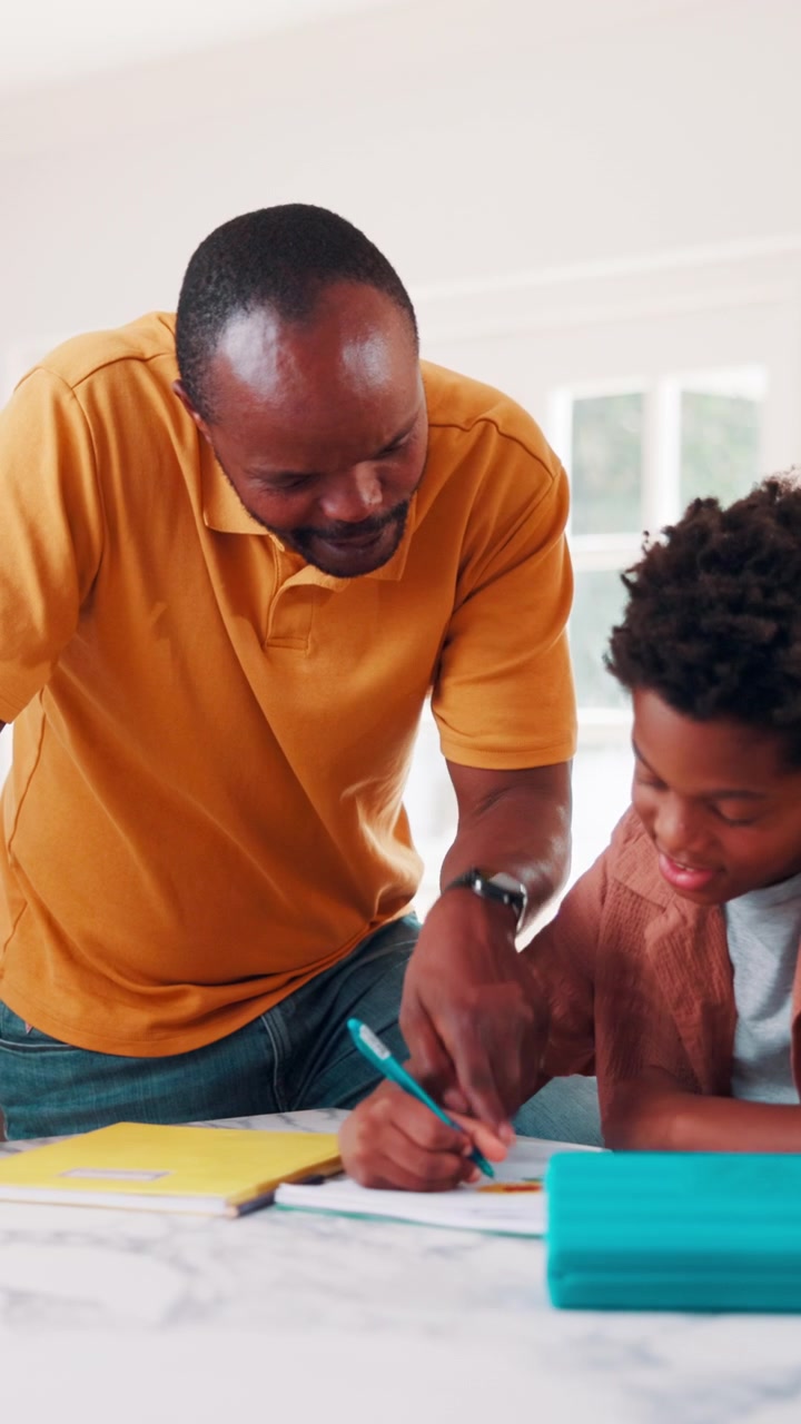 Father Helping His Son With Homework at Home