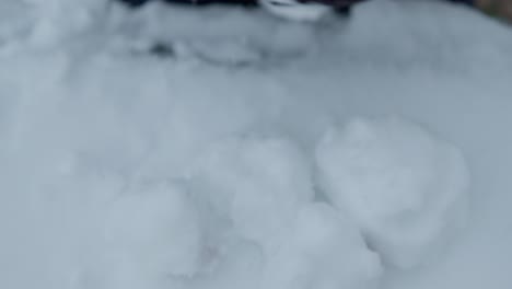 primer plano en cámara lenta de agarrar y quitar una pila de bolas de nieve con guantes negros
