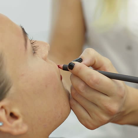 permanent make-up on her lips. portrait of lovely young woman getting permanent makeup on her lips