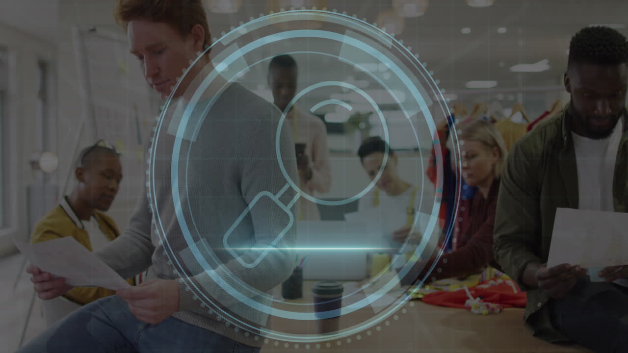 Animation of cyber security text and magnifying glass over diverse designers working in office