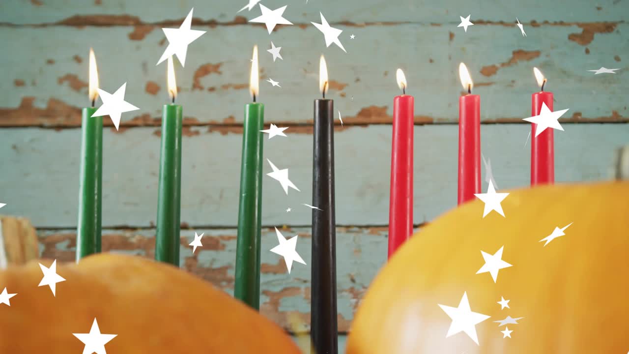 White stars drifting over tabletop beside pumpkins and grapes, candles lighting adding festive glow