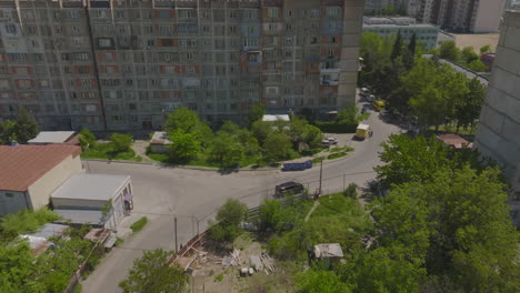 Aerial-tracking-shot-of-a-black-SUV-driving-past-run-down-apartment-complexes-in-Georgia