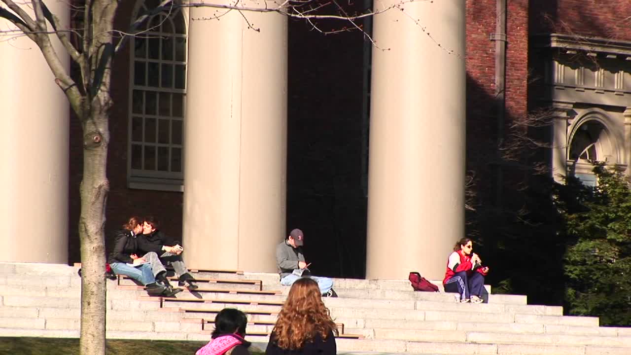 학생들은 하버드 대학교 교회 계단에 앉아 있다