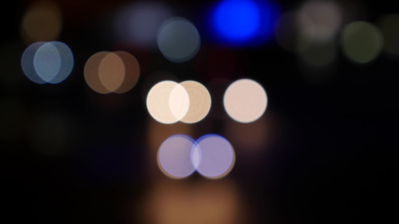 hermoso bokeh brillante en el fondo oscuro borroso por la noche. el redondo bokeh colorido brilla de las luces de los coches en la calle de la ciudad. fuera de foco con borroso. luces de la ciudad sin enfoque. bokeh de tráfico. concepto abstracto