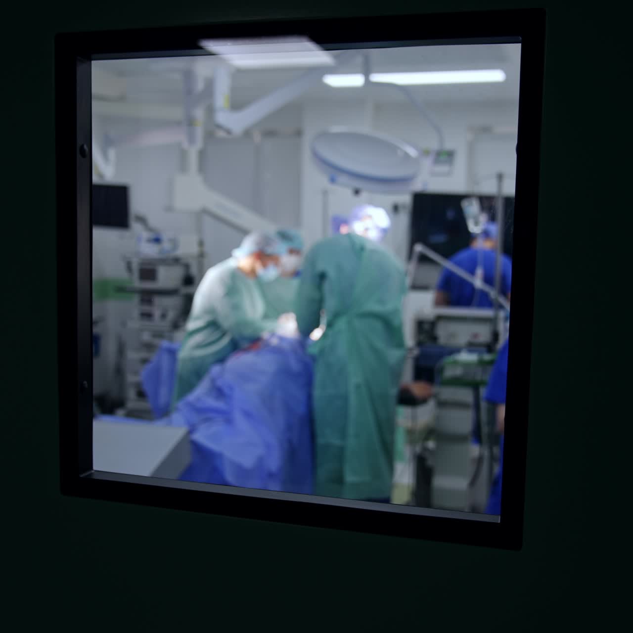 Equipo médico trabajando en el quirófano. Vista a través de la ventana de la puerta del quirófano