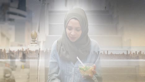 animation of asian woman in hijab eating salad over cityscape