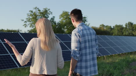 two people are talking around solar panels at a small home solar power plant. ecologically clean production of electricity