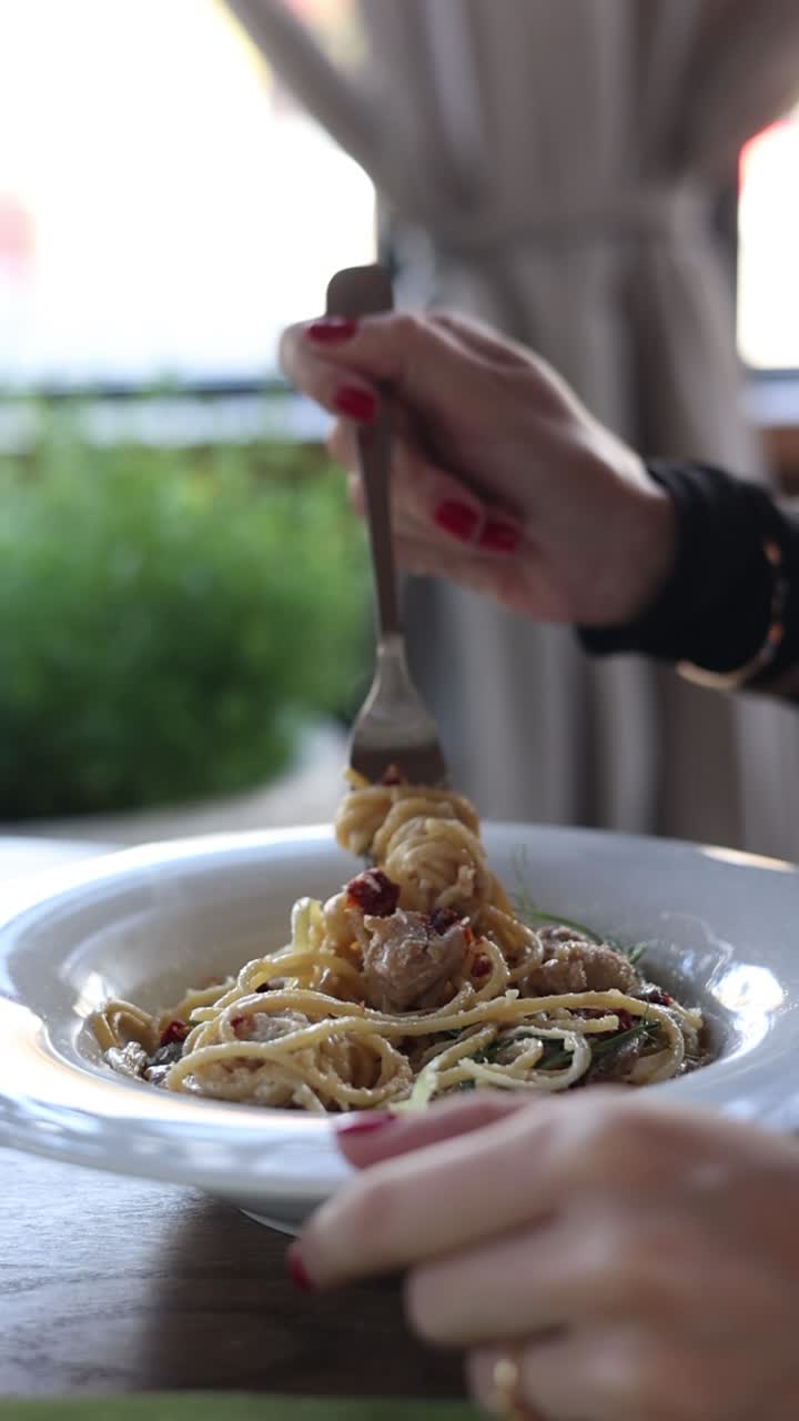 Donna che mangia spaghetti