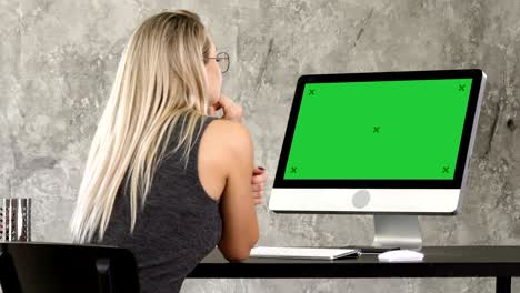 woman freelancer looking at computer monitor. green screen mock-up display
