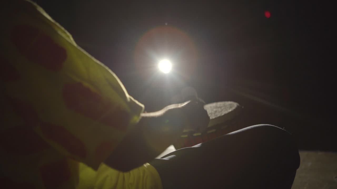 Child plays drums with lights flickering on and off.