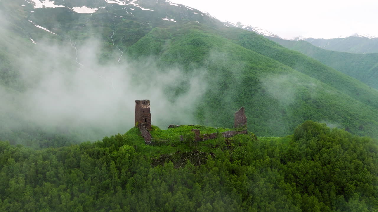 Misty Clouds With Watchtower Over Lush Valley Near Ushguli Village In Upper Svaneti, Georgia.