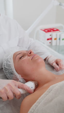 esteticista hace a la mujer rf lifting procedimiento de cosmetología de la cara y los ojos mascarilla de colágeno en el spa