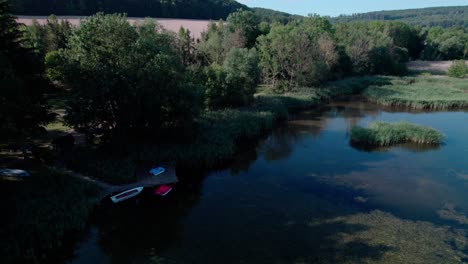 Some-boats-at-a-docking-station-an-a-bright-blue-lake-with-algae