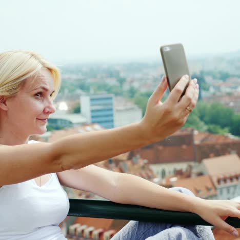 una joven se fotografía contra el paisaje urbano de graz en austria