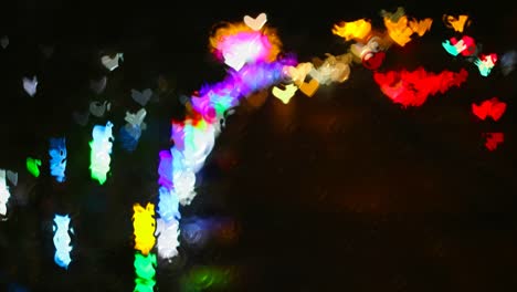 chuva fora da janela as ondas de água estavam no chão de vidro e as luzes do arco-íris em forma de coração da rua refletida em