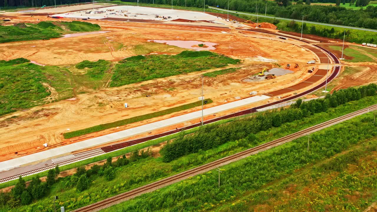 Railway construction site for industrial park development with cleared land and access roads in aerial view