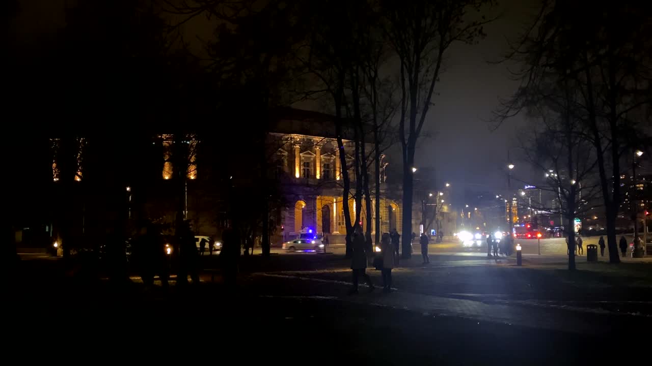 밤에 교통을 멈추는 경찰차가 있는 중앙 유럽 도시의 길모퉁이