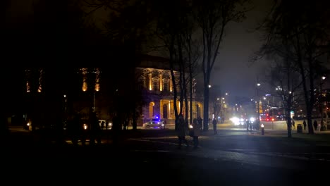 street corner in central european city with a police car stopping traffic at night