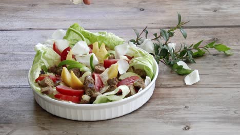 White-rose-petals-floating-onto-a-fresh-bowl-of-salad