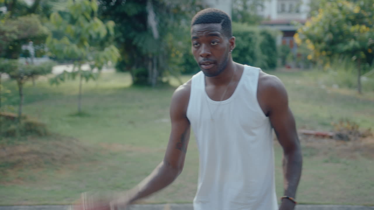 Black Basketball Player Dribbling Ball and Chatting with Friend outdoor