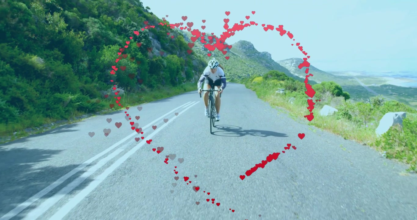 Ciclista pedaleando en carretera de montaña, con una animación de corazón rojo que brilla y gira, impulsando la resistencia física.
