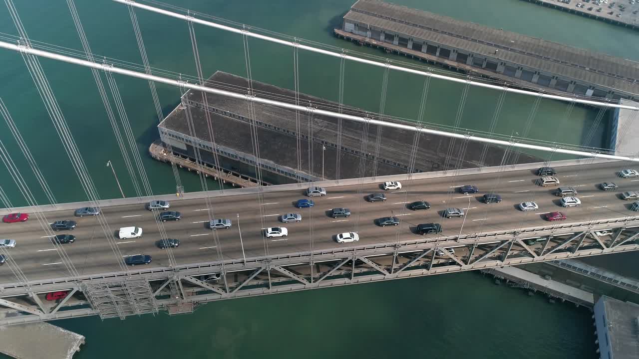 도시를 배경으로 샌프란시스코-오클랜드 베이 브릿지에서 이동하는 차량의 공중 촬영