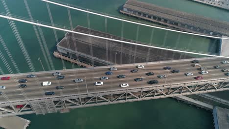 aerial shot of vehicles moving on san francisco–oakland bay bridge with city in background