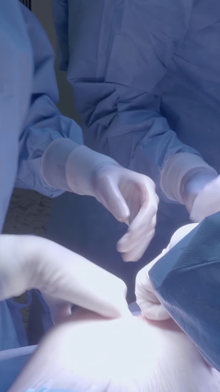 Sağlık profesyonelleri, steril bir ortamda odaklanmış bir hassasiyetle cerrahi bir işlem gerçekleştiriyor.