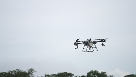 slow tracking shot of a dji agrad t30 scanning a farmers field ready to spray