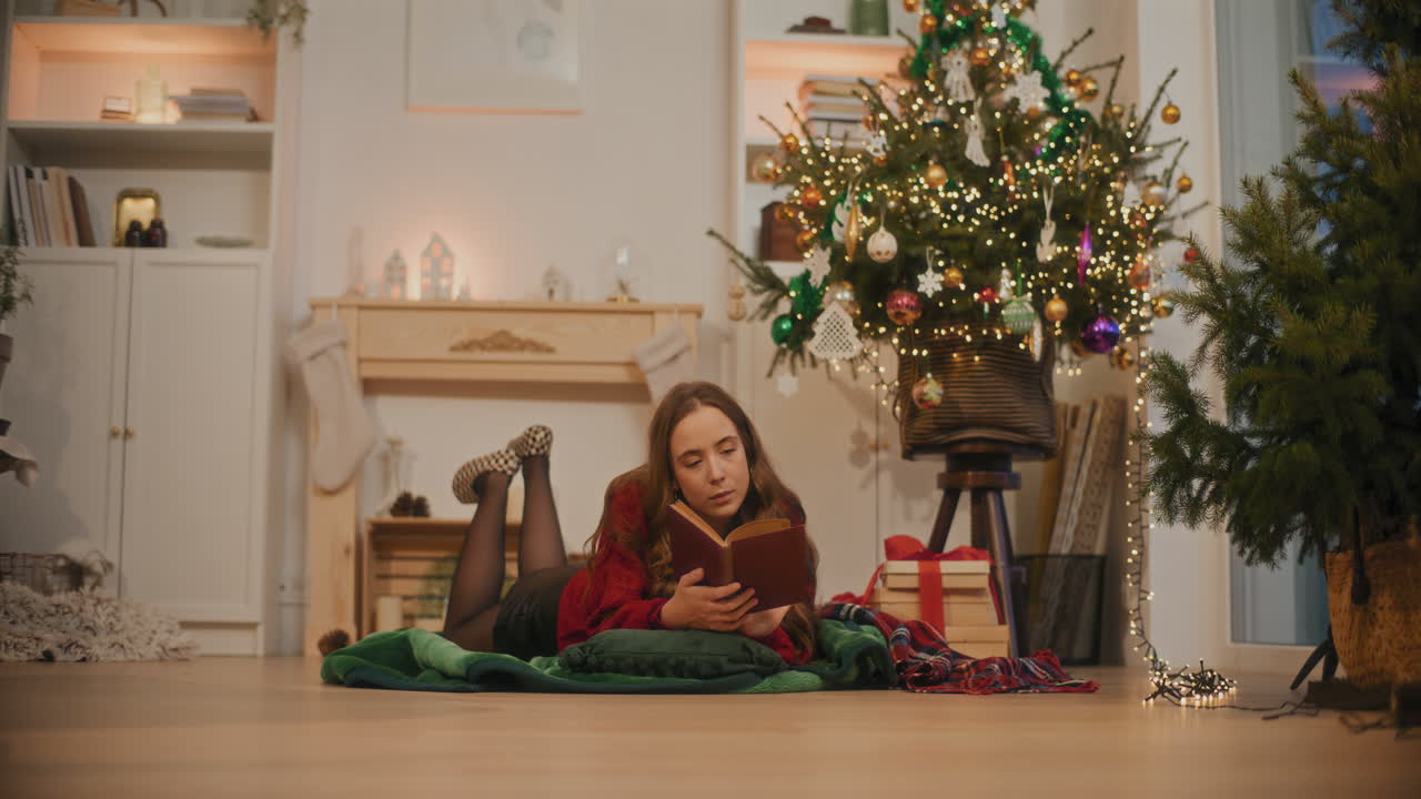 mujer leyendo un libro mientras se acuesta en la sala de estar