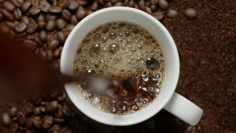 coffee is being poured into a coffee cup