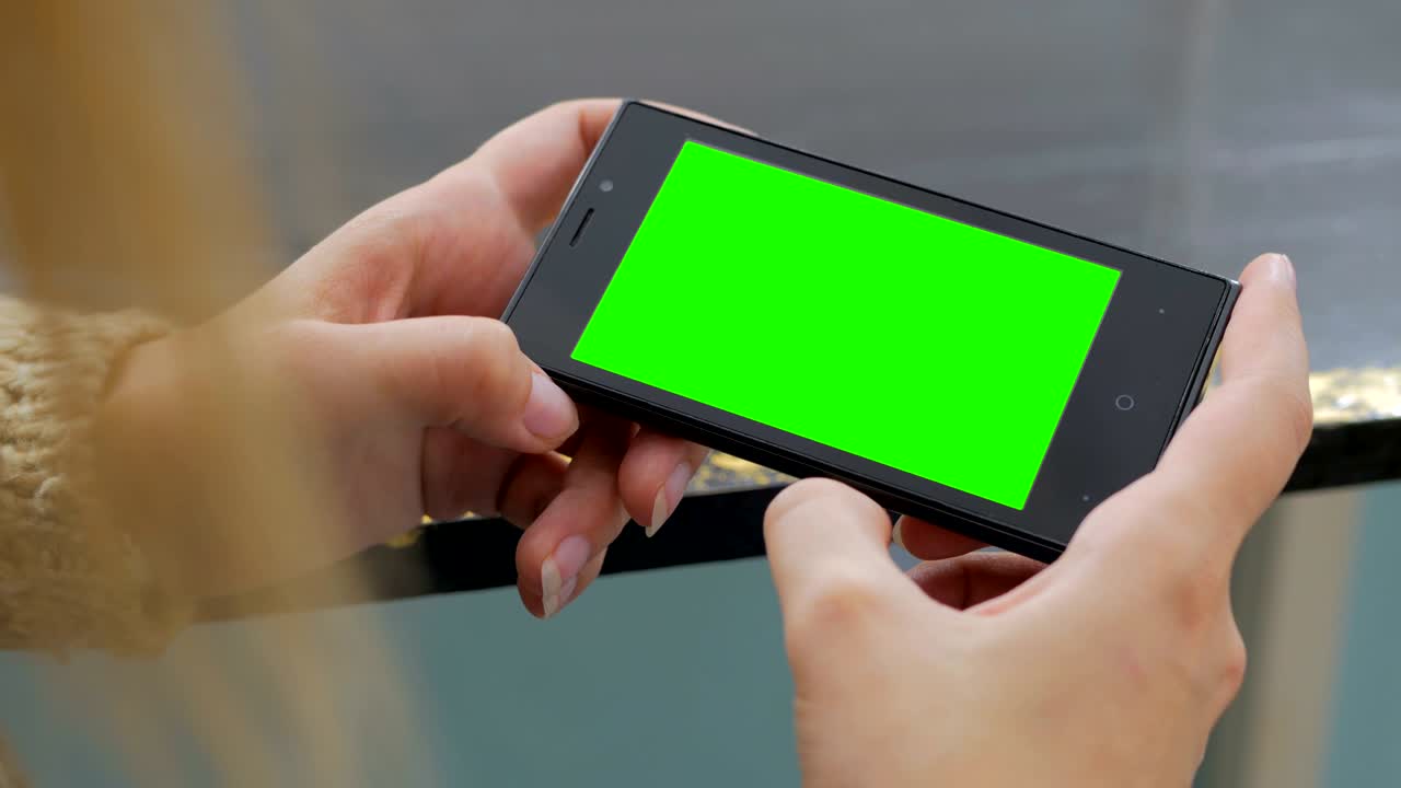 mujer mirando un teléfono inteligente con pantalla verde