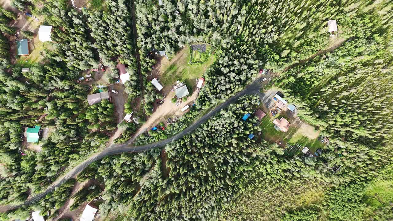 Rural Alaska homestead nestled in lush green forest from above - experience the serene beauty and peaceful isolation of life off the grid