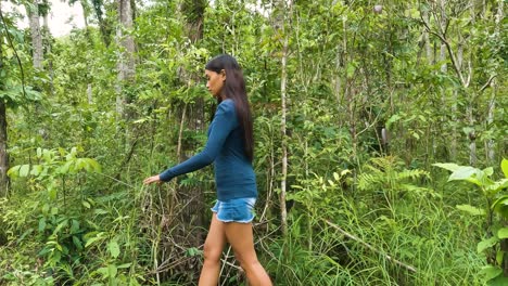 Young-Female-Walks-Along-Grassy-Forest-With-Dense-Vegetations-And-Trees