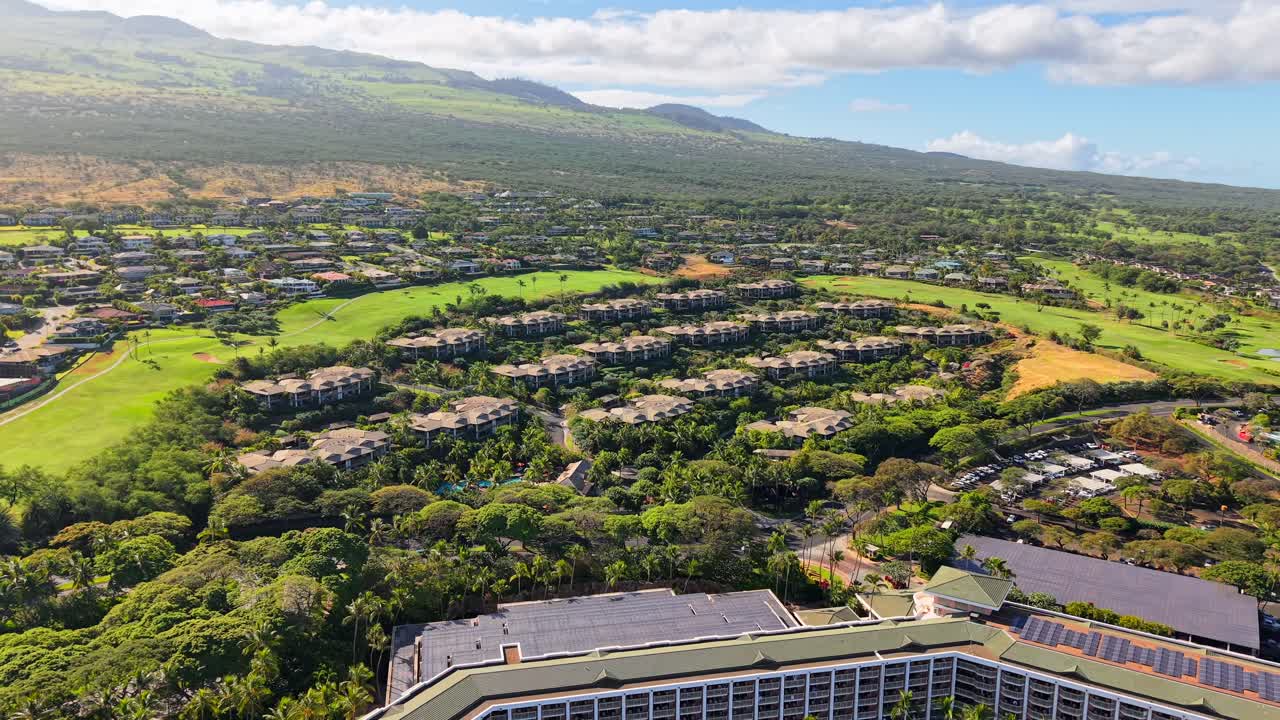 Luxury residential villas and golf course community on a tropical Maui hillside, aerial