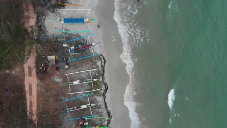 Traditional-fishing-boats-on-Serdang-beach-at-Indonesia,-aerial