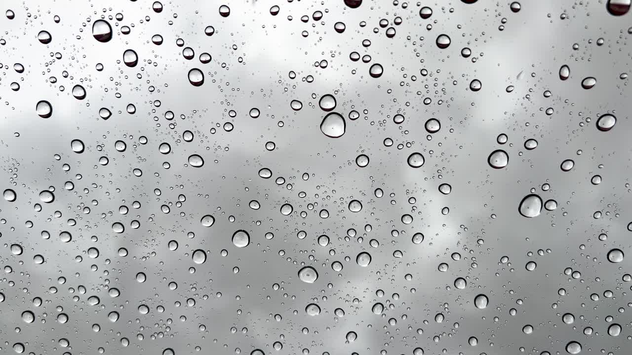papel tapiz vertical de primer plano en tiempo real gotas de lluvia cayendo sobre el vidrio en un día gris frío y lluvioso