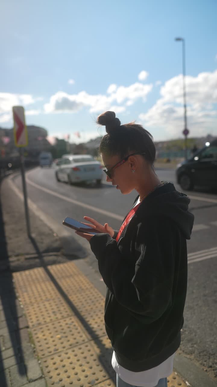 Giovane donna che usa lo smartphone in una strada della città