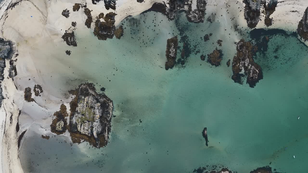 Vista a volo d'uccello della spiaggia di Traigh, Scozia, con kayakisti su acque simili a quelle caraibiche.