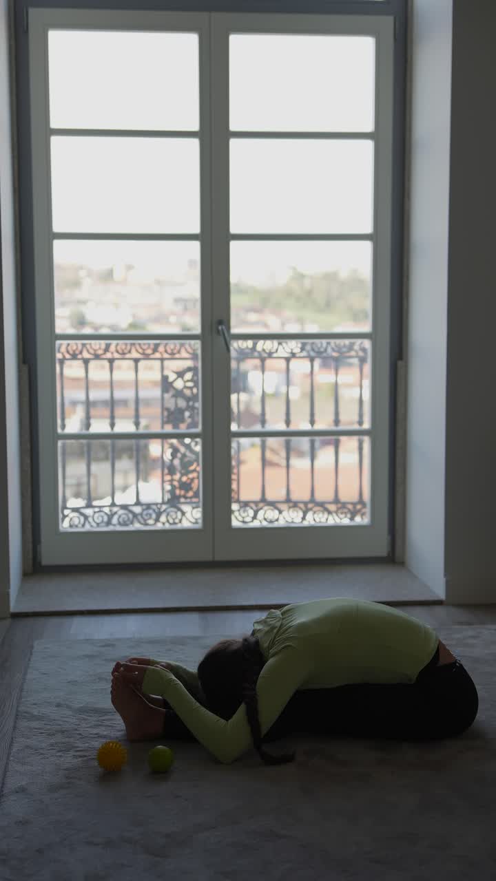 mujer estirándose en una habitación con una vista