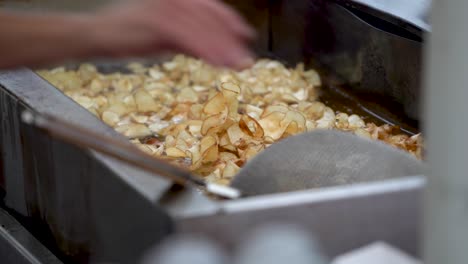 primer plano de una freidora de aceite caliente con patatas tornado fritas rizadas cocinando