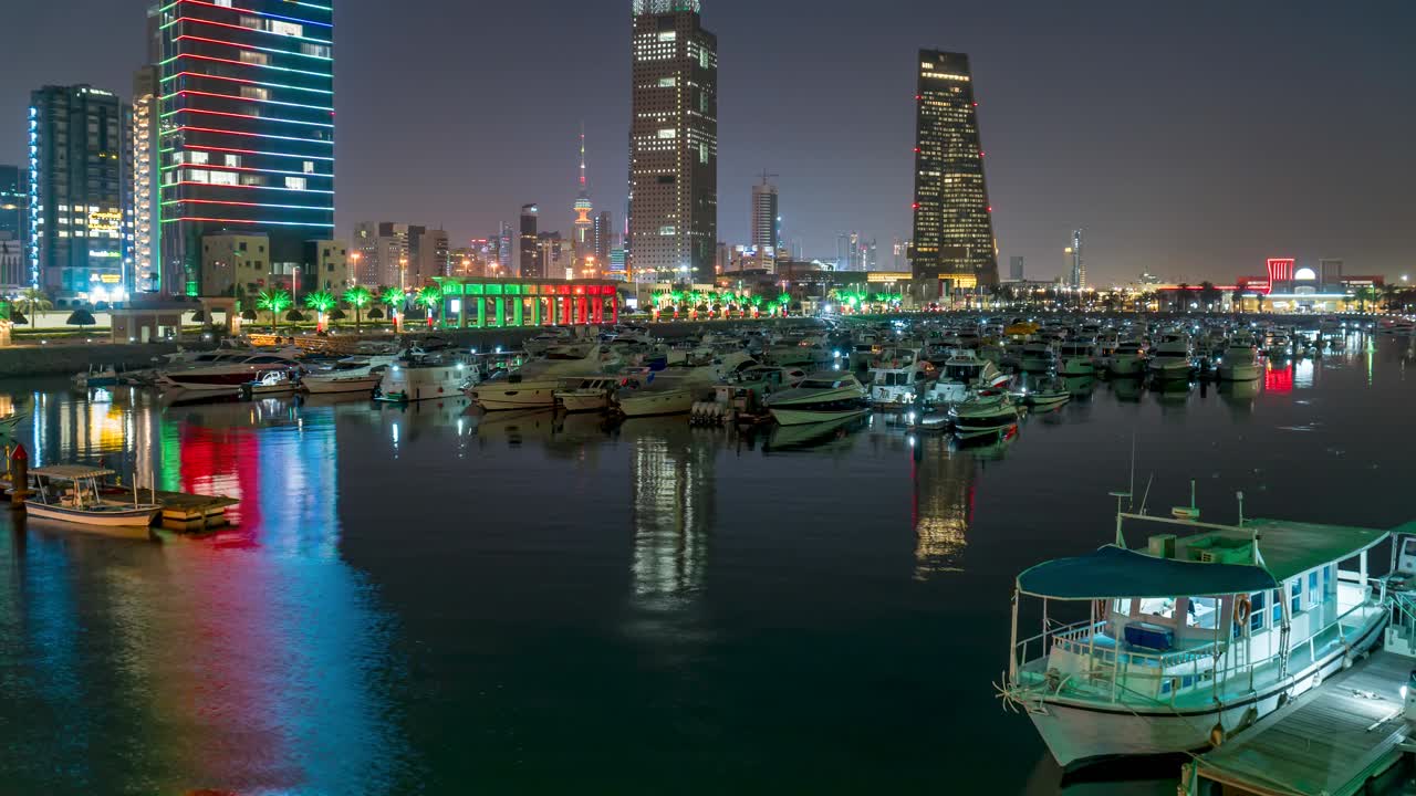 Boats in Souk Sharq Marina, Kuwait with skyline in background, night time lapse