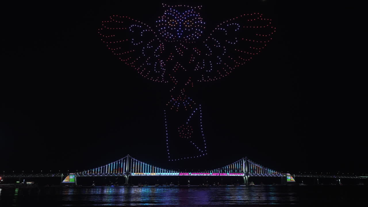 Gwangalli Beach Drone Light Show Above Gwangan Bridge in Busan, South Korea. Glowing Flying Drones Hive Froming Owl Figure Carrying Letter