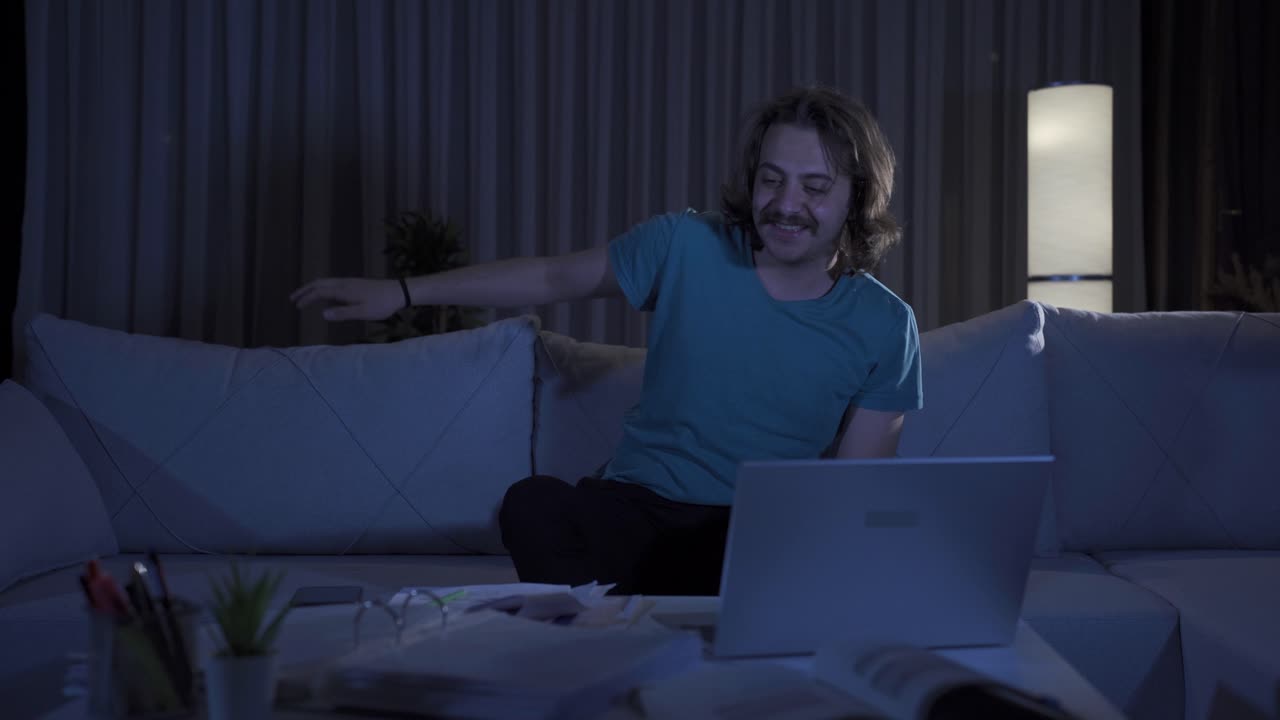 un joven feliz y alegre que se siente enérgico en casa por la noche.